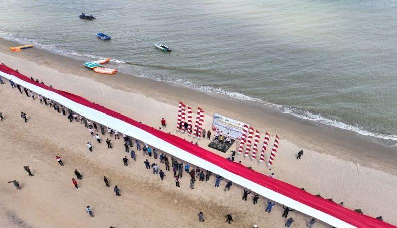 Jelang HUT RI, TNI-Polri Bentangkan Bendera 250 Meter di Pantai Kalsel