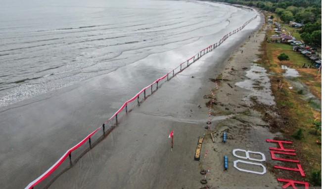 Warga Konawe Bentangkan Bendera Merah Putih Sepanjang 580 Meter di Pantai Tanjung Lalimbue