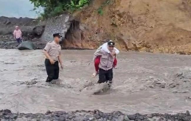 Polisi Gendong Siswa SD Seberangi Lahar Dingin Semeru di Lumajang