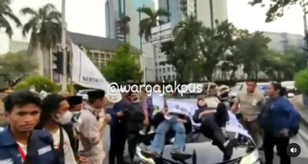 Viral! Pendemo Duduk dan Rebahkan Badan di atas Kap Mobil Wali Kota Cilegon