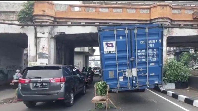 Truk Kontainer Tersangkut di Kolong Jembatan Rel Kereta di Matraman
