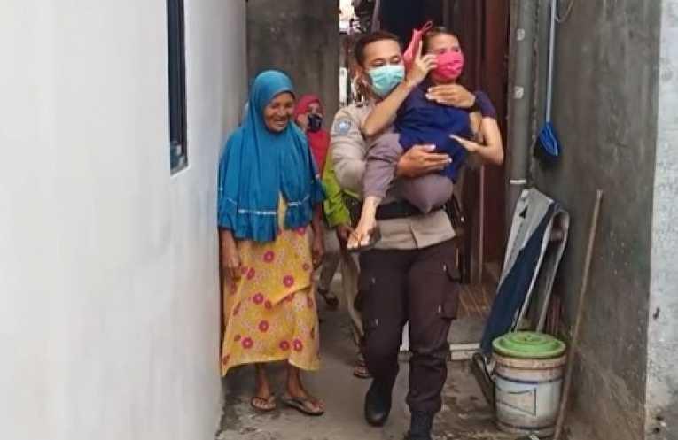 Keren! Anggota Polri Ini Bopong Ibu Disabilitas untuk Vaksinasi Covid-19
